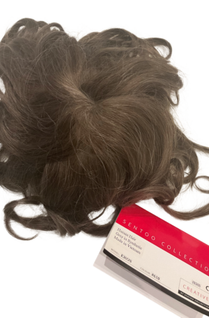 Photo of a male toupee in a medium brown color with flex of grey. Label with Sentoo to collection EROS – 610.